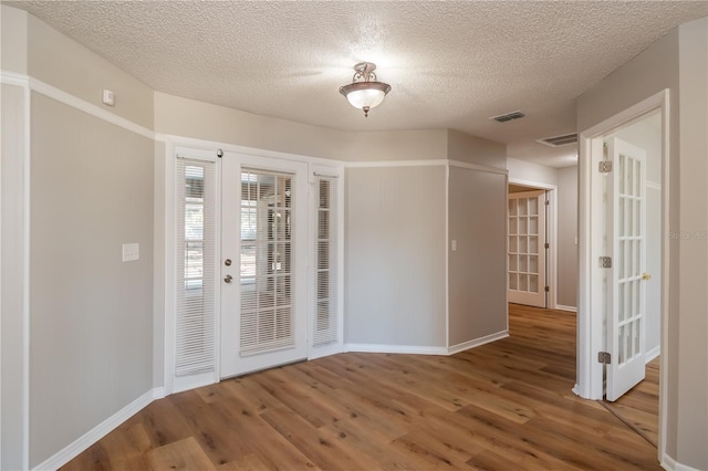 empty room featuring hardwood / wood-style floors and a textured ceiling