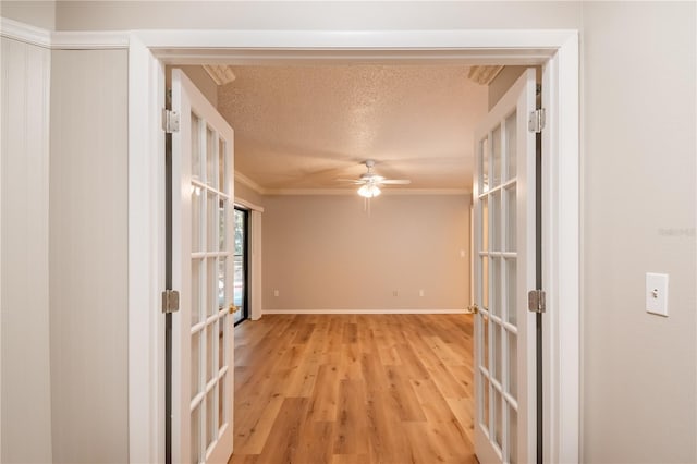 spare room featuring french doors, crown molding, ceiling fan, a textured ceiling, and light hardwood / wood-style floors