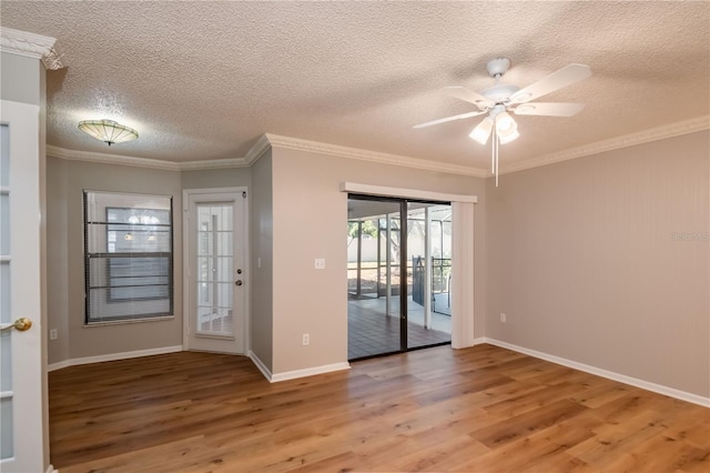 spare room with a textured ceiling, ceiling fan, wood-type flooring, and crown molding