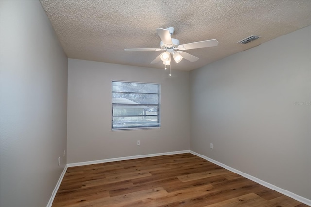 unfurnished room featuring ceiling fan, wood-type flooring, and a textured ceiling