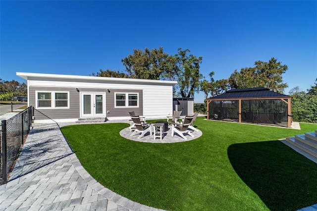 back of house with a gazebo, a yard, a fire pit, and french doors