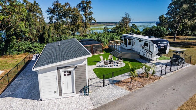 exterior space with an outdoor structure, a deck with water view, and a fire pit