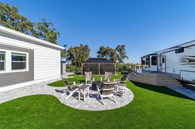 view of yard with a gazebo, a patio, an outdoor fire pit, and a wooden deck