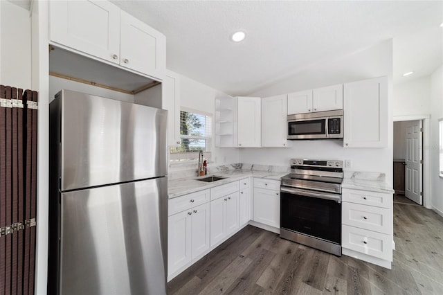 kitchen featuring appliances with stainless steel finishes, light stone counters, dark wood-type flooring, sink, and white cabinets