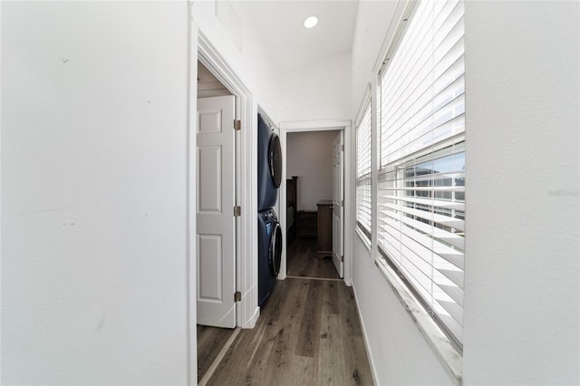 hallway with dark hardwood / wood-style flooring and stacked washer and dryer