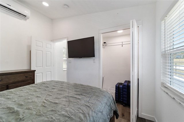 bedroom featuring hardwood / wood-style floors, a wall unit AC, and a closet