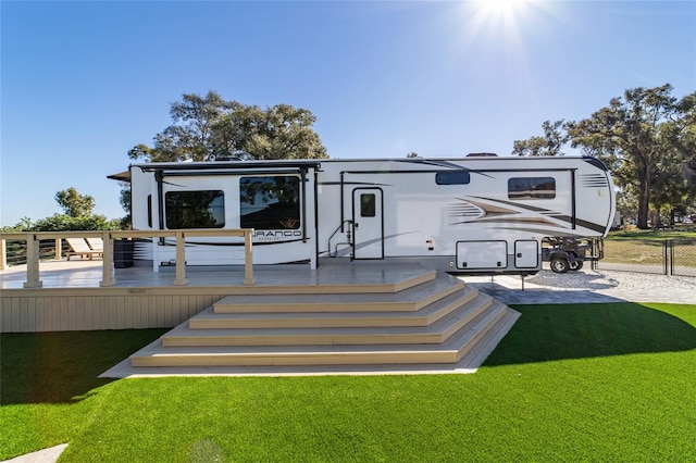 rear view of property with a yard and a deck