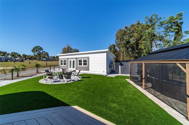 rear view of property featuring a lawn, a storage unit, and a deck