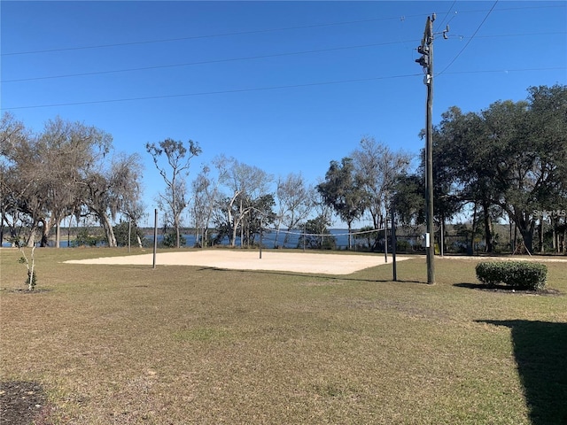 view of property's community with volleyball court and a lawn