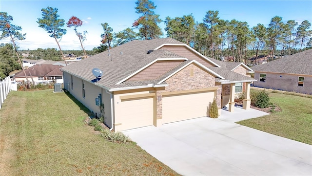 view of front of home with central AC, a front lawn, and a garage