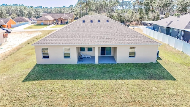 back of property with a yard and a patio area