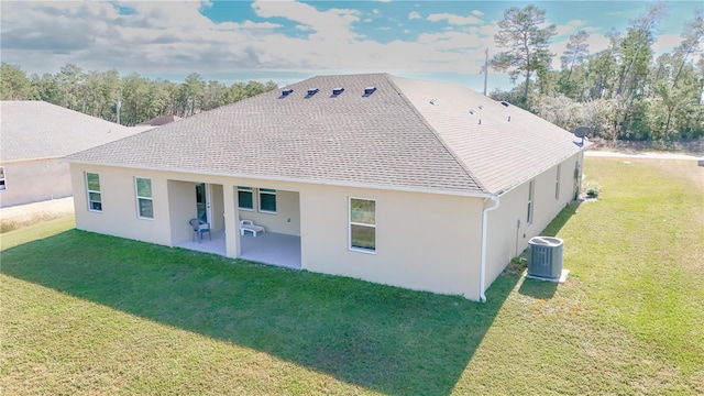 back of property featuring a yard, cooling unit, and a patio