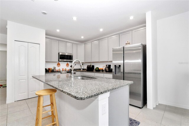 4313 SW 106th Pl, Ocala, FL 34476 - kitchen featuring appliances with stainless steel finishes, a sink, light tile patterned floors, gray cabinetry, and light stone countertops