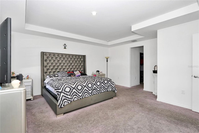 bedroom with carpet flooring and a raised ceiling