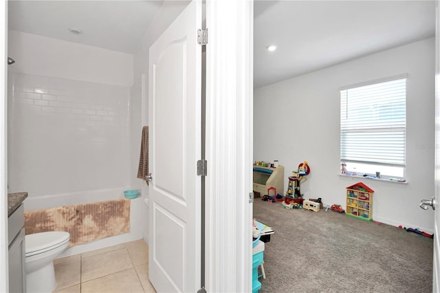 interior space with tile patterned flooring, vanity, toilet, and tiled shower / bath combo