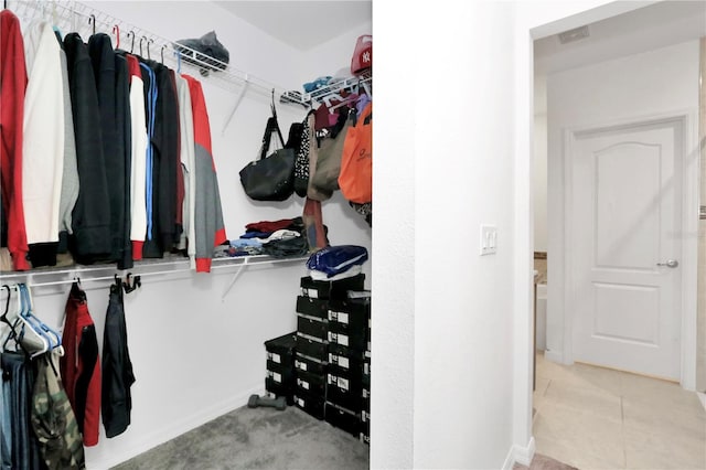 walk in closet with light tile patterned floors