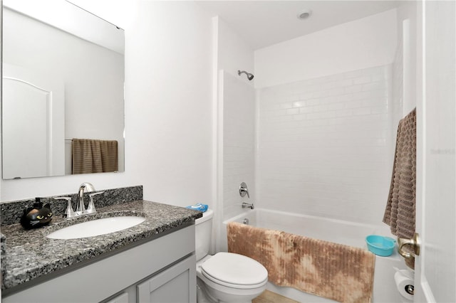 full bathroom with vanity, tiled shower / bath combo, and toilet