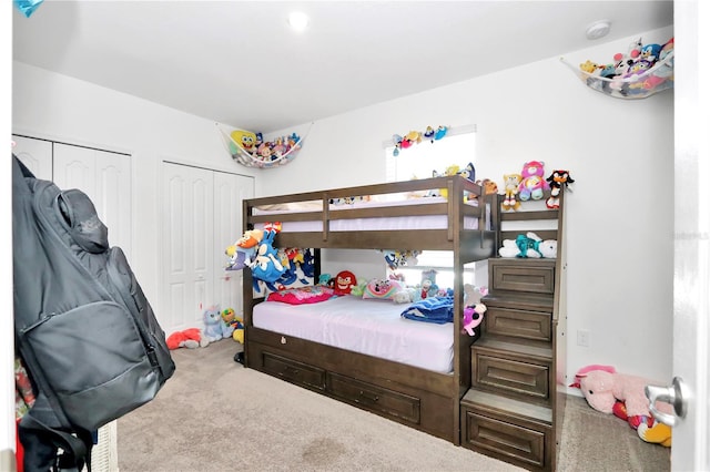 bedroom with carpet floors and two closets