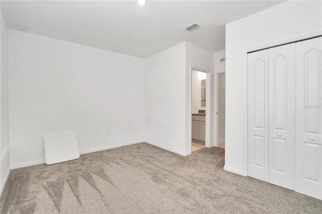 unfurnished bedroom with light carpet and a closet