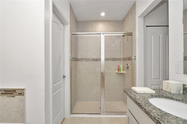 bathroom featuring tile patterned flooring, vanity, and an enclosed shower