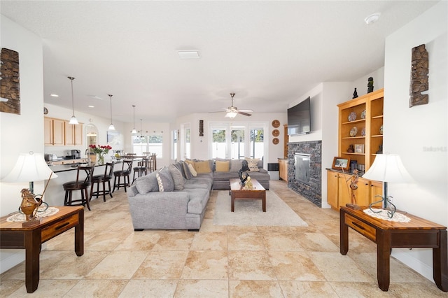 living room featuring a fireplace and ceiling fan