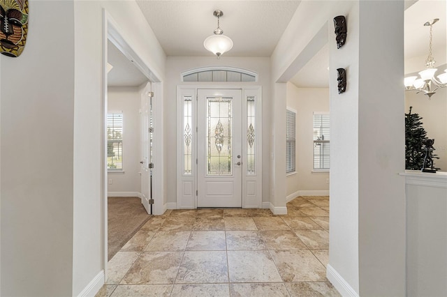 foyer entrance with plenty of natural light and a notable chandelier