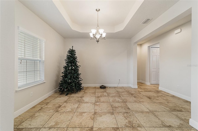 unfurnished dining area with a raised ceiling and an inviting chandelier