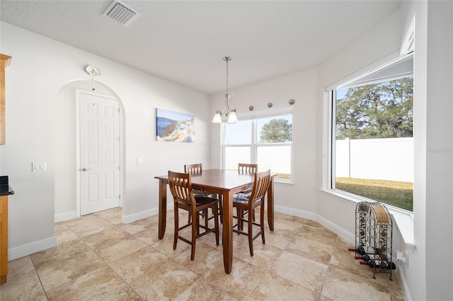 dining space with a chandelier and a textured ceiling