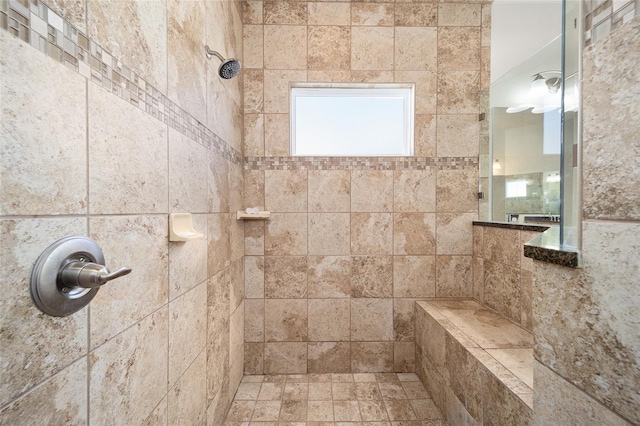 bathroom with a tile shower and tile walls