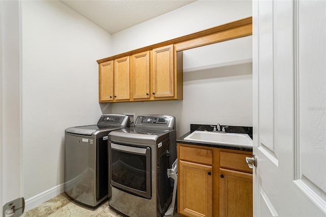 washroom featuring separate washer and dryer, sink, and cabinets