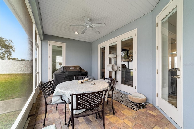 sunroom / solarium with french doors, plenty of natural light, and ceiling fan