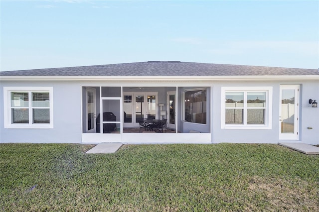 back of house featuring a yard and a sunroom