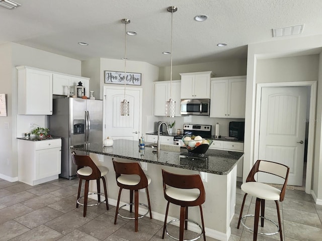 kitchen featuring white cabinetry, a kitchen island with sink, sink, and stainless steel appliances