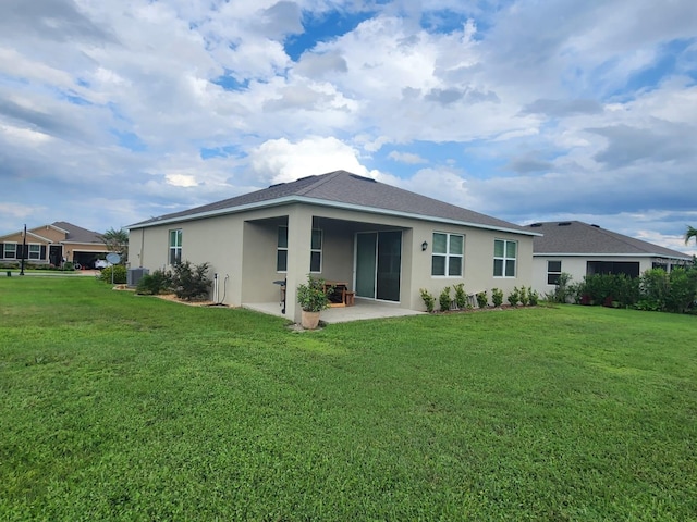 rear view of house featuring a lawn and a patio