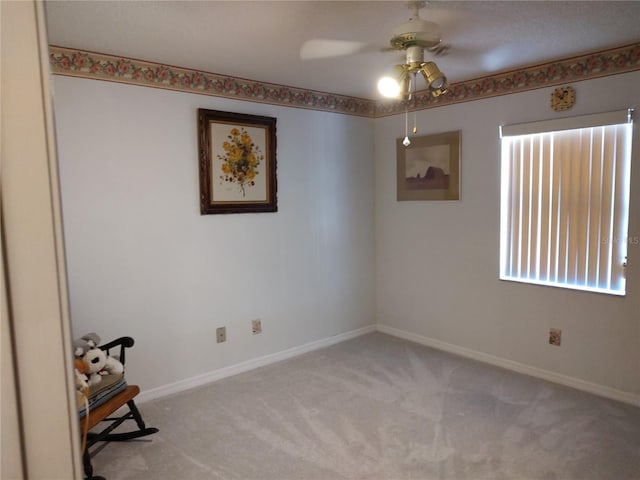 carpeted spare room featuring ceiling fan