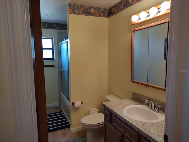 full bathroom featuring vanity, shower / bath combination with glass door, toilet, and wood-type flooring