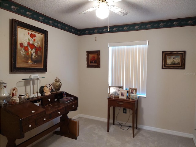 carpeted office with a textured ceiling and ceiling fan