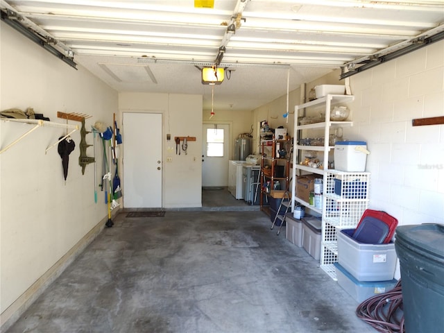 garage with washer and dryer, a garage door opener, and water heater