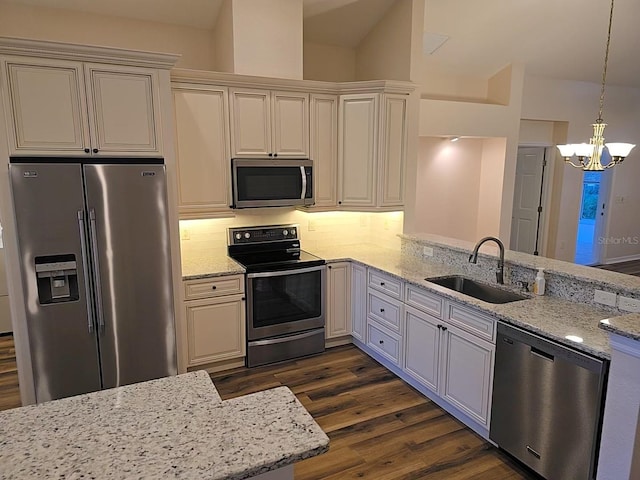 kitchen featuring pendant lighting, sink, appliances with stainless steel finishes, dark hardwood / wood-style floors, and light stone counters