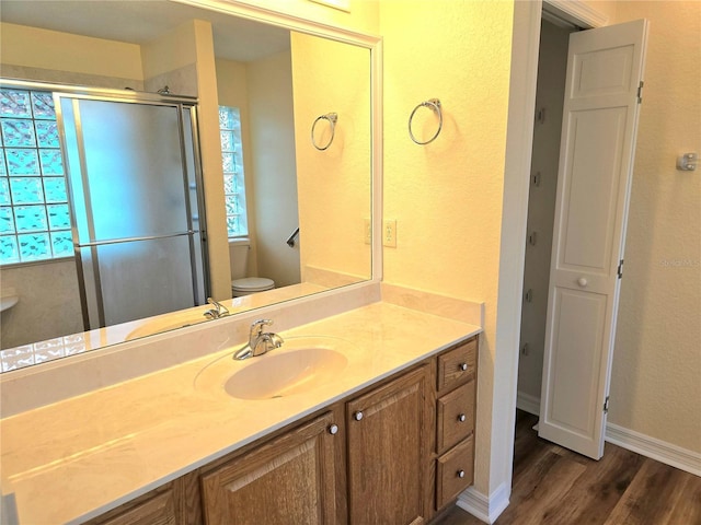 bathroom with vanity, hardwood / wood-style flooring, plenty of natural light, and toilet