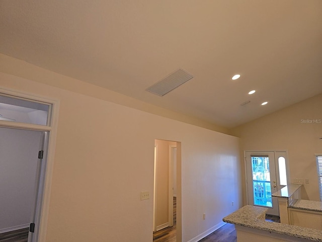 interior space with light stone counters, lofted ceiling, and dark hardwood / wood-style flooring