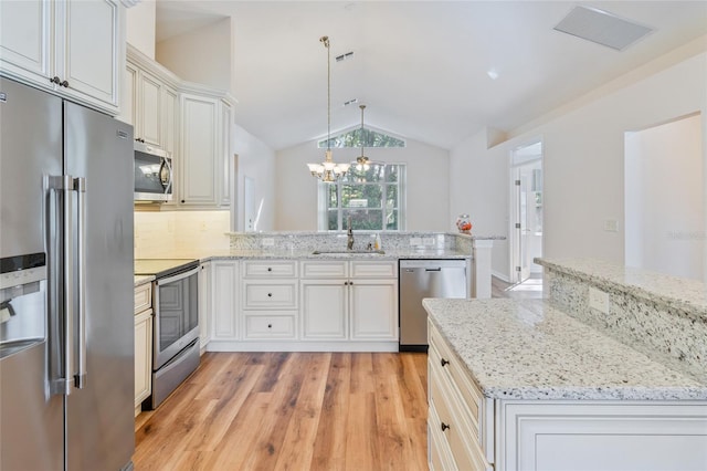 kitchen featuring sink, appliances with stainless steel finishes, hanging light fixtures, vaulted ceiling, and kitchen peninsula