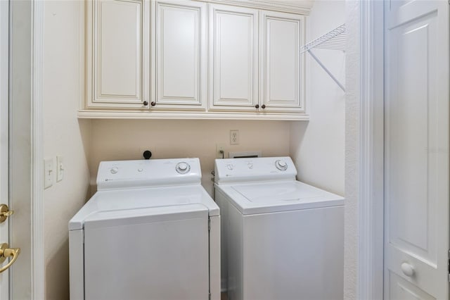 clothes washing area featuring cabinets and washer and dryer