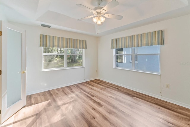 unfurnished room featuring ceiling fan, a raised ceiling, and light hardwood / wood-style floors