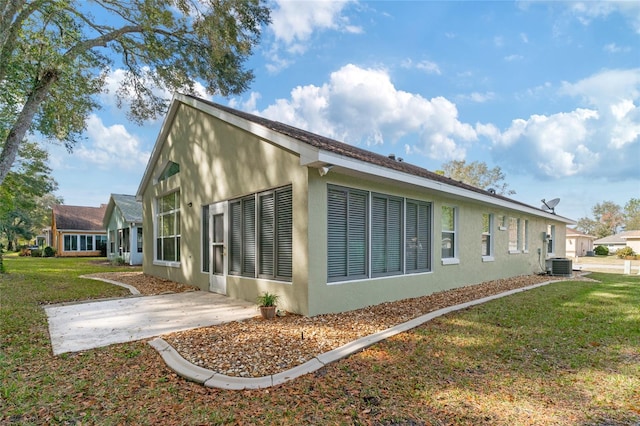 view of home's exterior featuring cooling unit, a yard, and a patio area