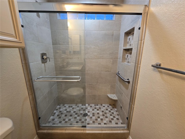 bathroom featuring an enclosed shower and toilet