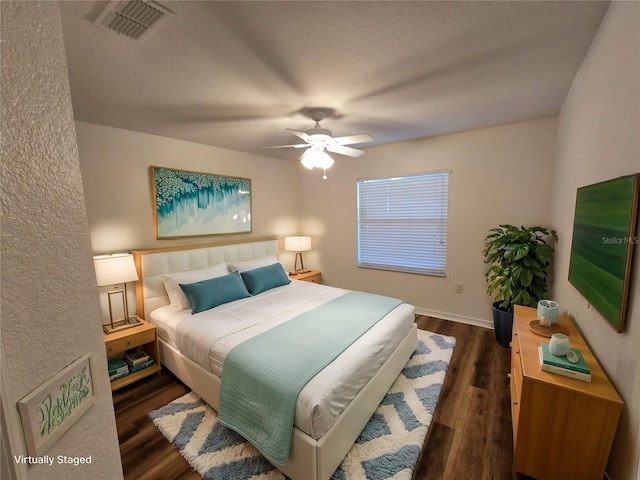 bedroom featuring ceiling fan, a textured ceiling, and dark hardwood / wood-style flooring