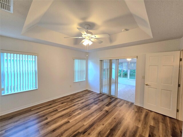 unfurnished room featuring hardwood / wood-style flooring, a raised ceiling, and ceiling fan