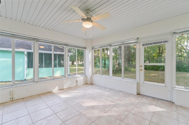 unfurnished sunroom featuring ceiling fan and plenty of natural light