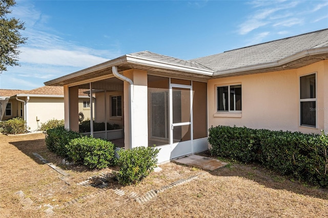 back of property with a sunroom